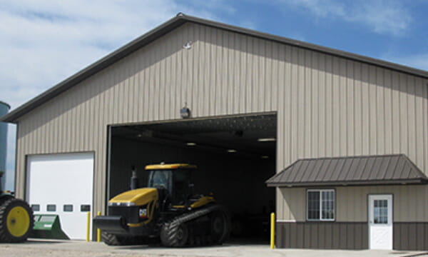 grey farm with yellow tractor in its doors